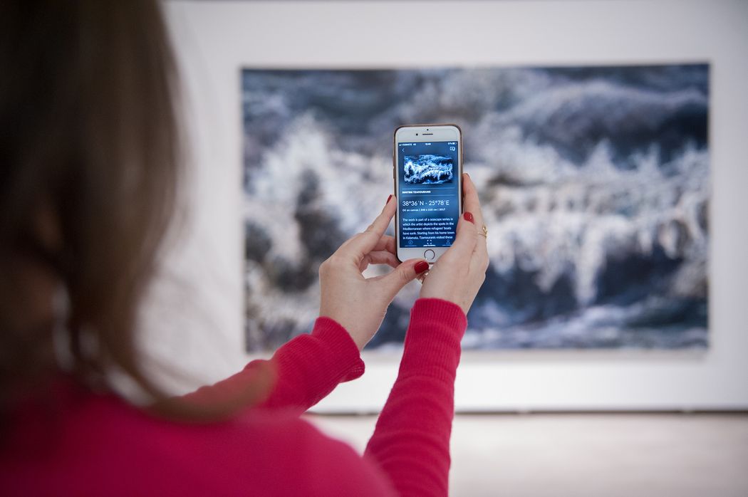 A person holding a phone up to a painting in a gallery and using the Smartify app to scan artwork A person holding a phone up to a painting in a gallery and using the Smartify app to scan artwork